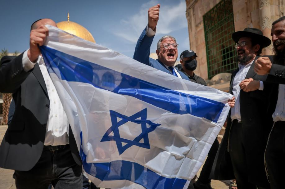 National Security Minister Itamar Ben Gvir waves the Israeli flag as he tours the Temple Mount in Jerusalem's Old City. May 14, 2026. (Yonatan Sindel/FLASH90)