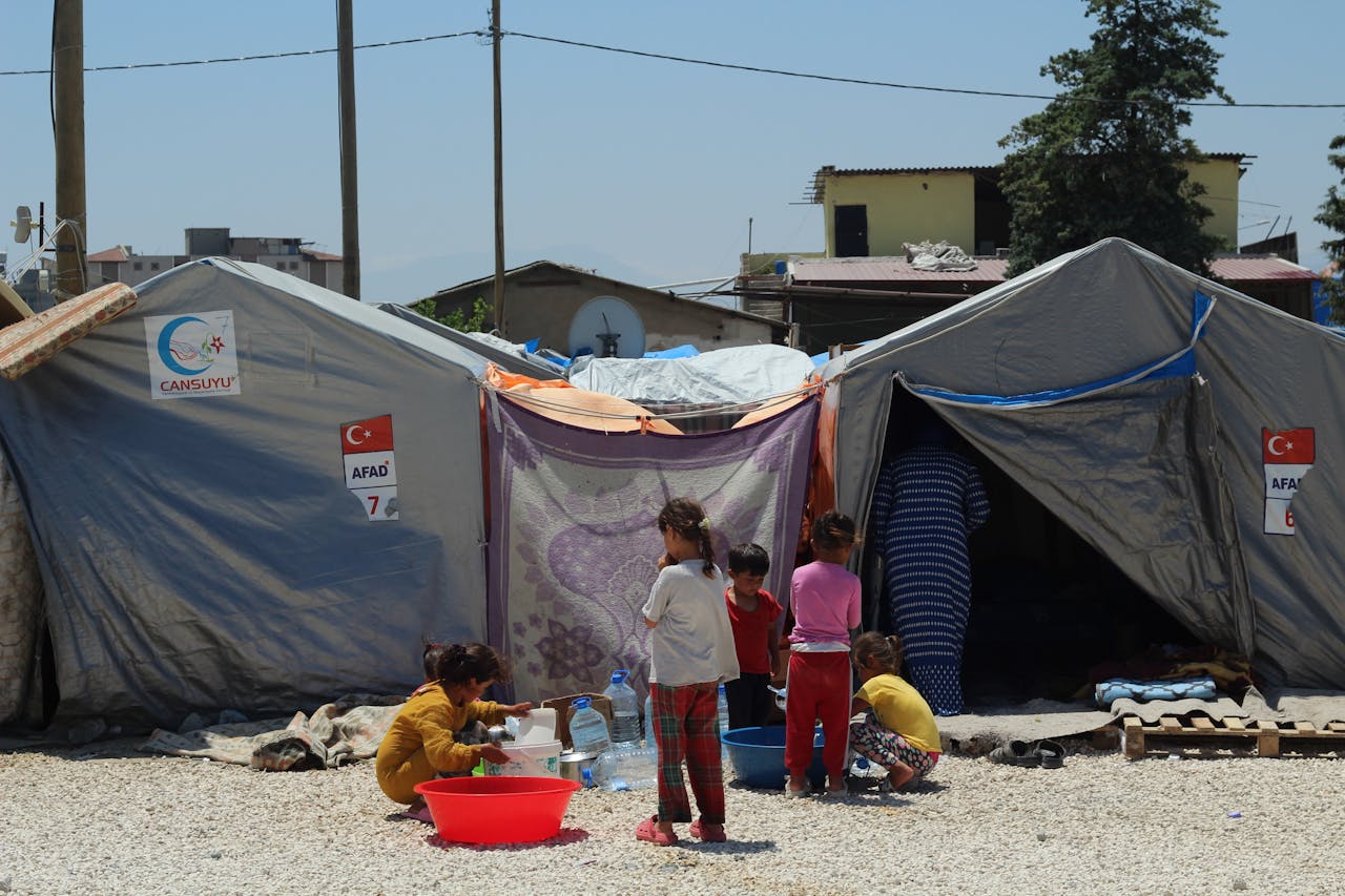 Group of children at a temporary tent camp highlighting post-disaster resilience.